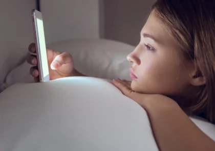 girl using phone on the bed