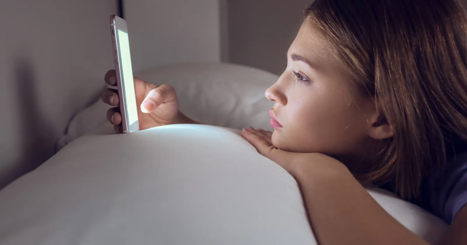 girl using phone on the bed